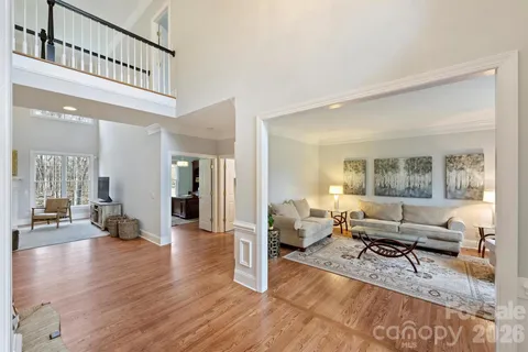 a living room with furniture stairs and a wooden floor