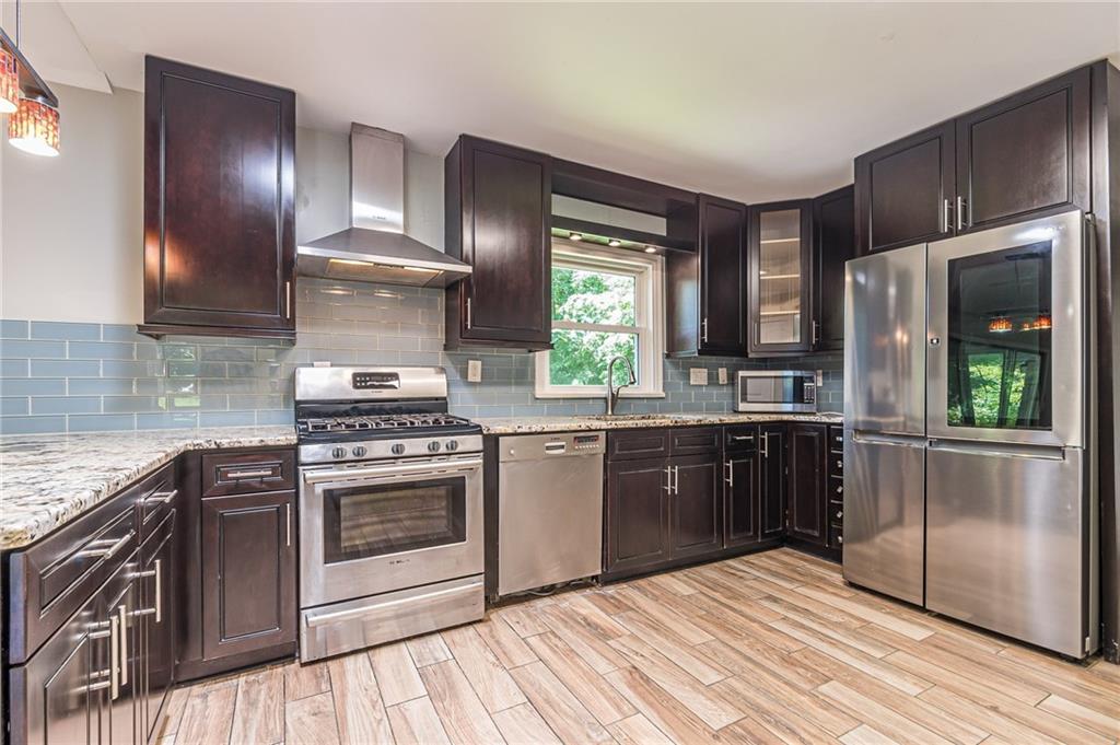 1574 Old Spring House Lane Atlanta, GA 30338 - Photo 16 of 55 a kitchen with a stove a sink and a refrigerator