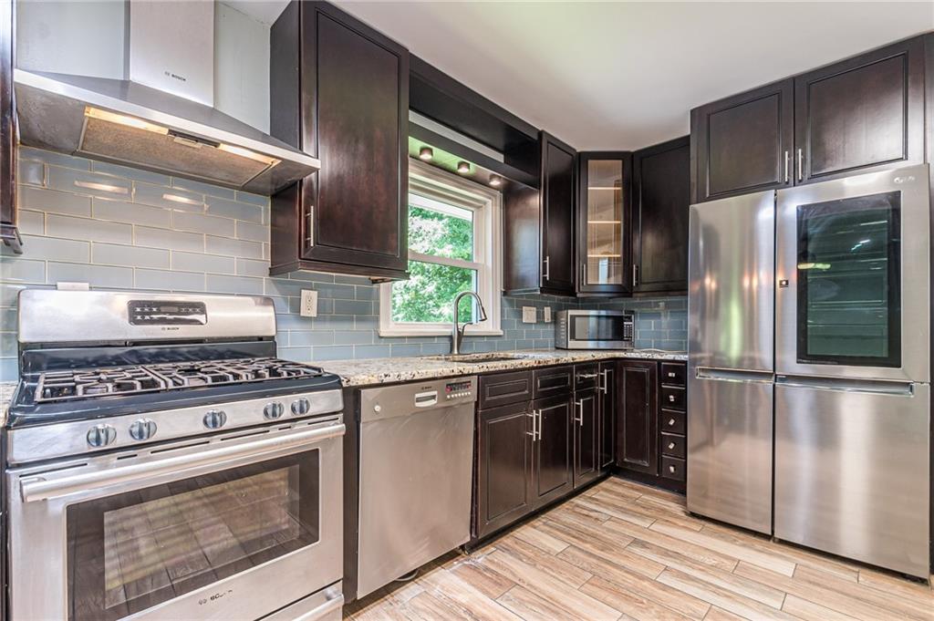 1574 Old Spring House Lane Atlanta, GA 30338 - Photo 18 of 55 a kitchen with stainless steel appliances granite countertop a stove a refrigerator and a sink