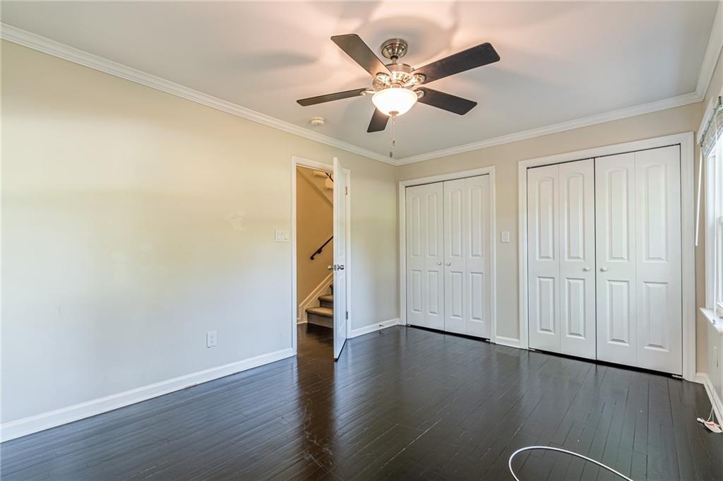 1574 Old Spring House Lane Atlanta, GA 30338 - Photo 39 of 55 an empty room with wooden floor chandelier fan and windows