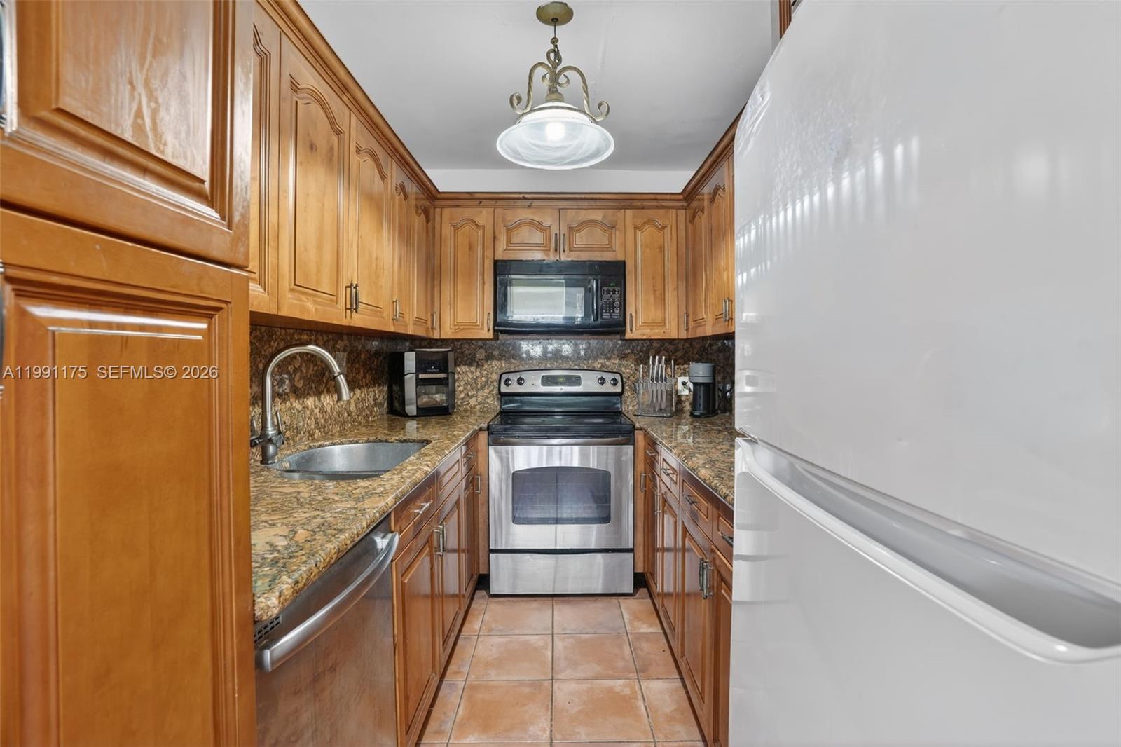 10055 Southwest 52nd Terrace Miami, FL 33165 - Photo 11 of 36 a kitchen with a sink and a stove top oven