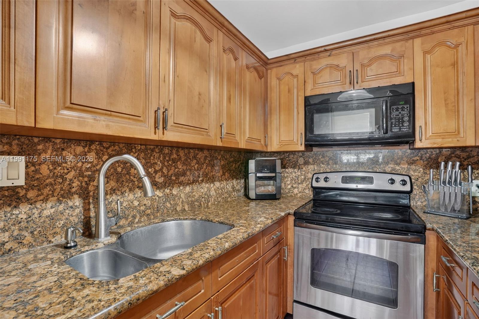 10055 Southwest 52nd Terrace Miami, FL 33165 - Photo 12 of 36 a kitchen with granite countertop a sink stainless steel appliances and cabinets