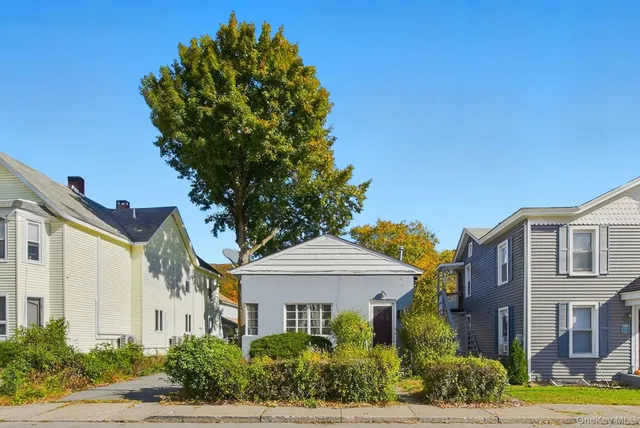 a front view of a multi story residential apartment building with yard and green space