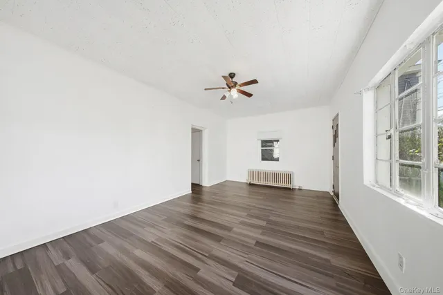 a view of a livingroom with wooden floor and a ceiling fan