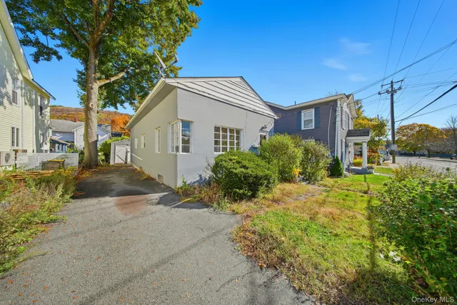 a view of a house with a yard and potted plants