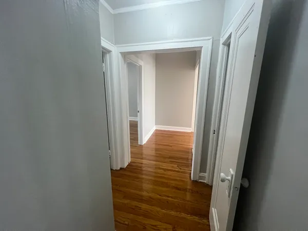 a view of a hallway with wooden floor and staircase