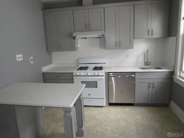 a kitchen with a stove sink and cabinets