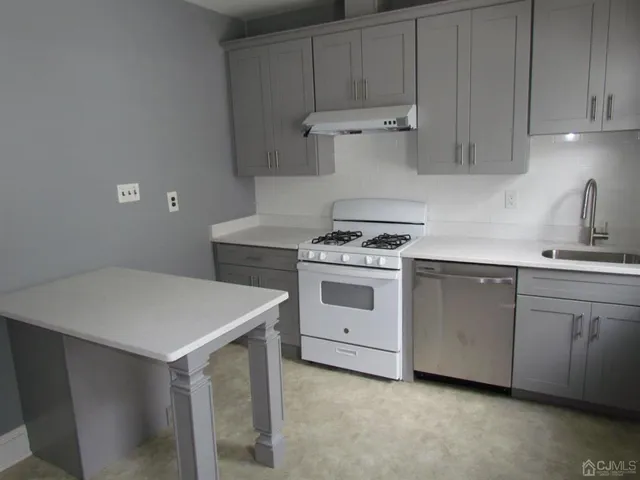 a kitchen with white cabinets and white appliances