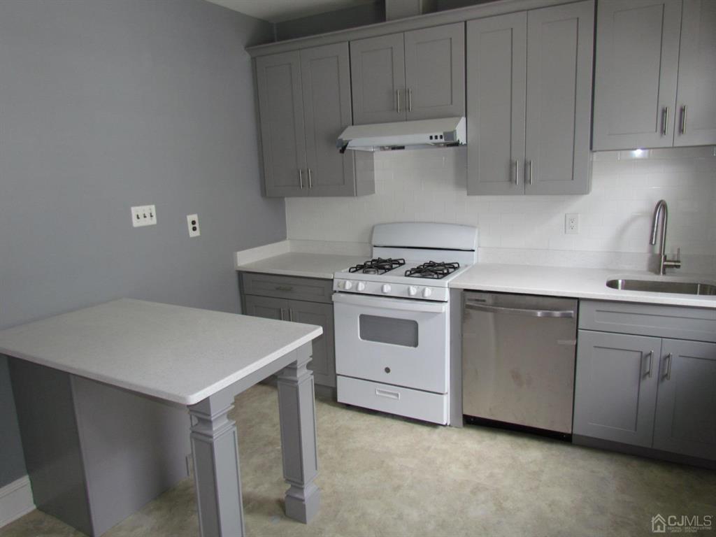 421 Magnolia Street, Unit 2 Highland Park, NJ 08904 - Photo 7 of 14 a kitchen with white cabinets and white appliances