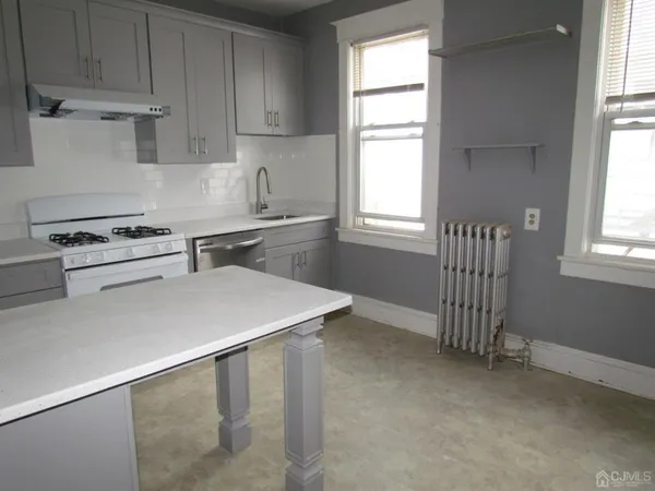 a kitchen with a stove a sink and a window