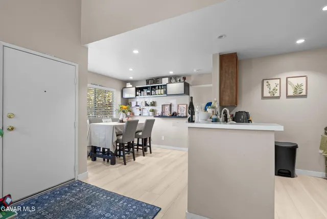 a kitchen with kitchen island a dining table chairs and white stainless steel appliances