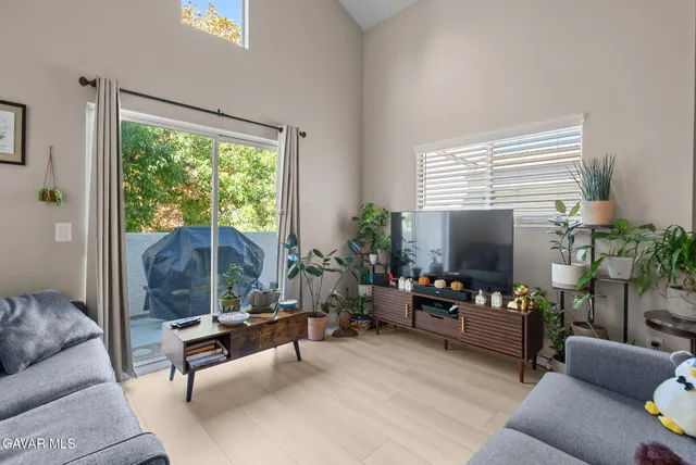 a living room with furniture a large window and a flat screen tv
