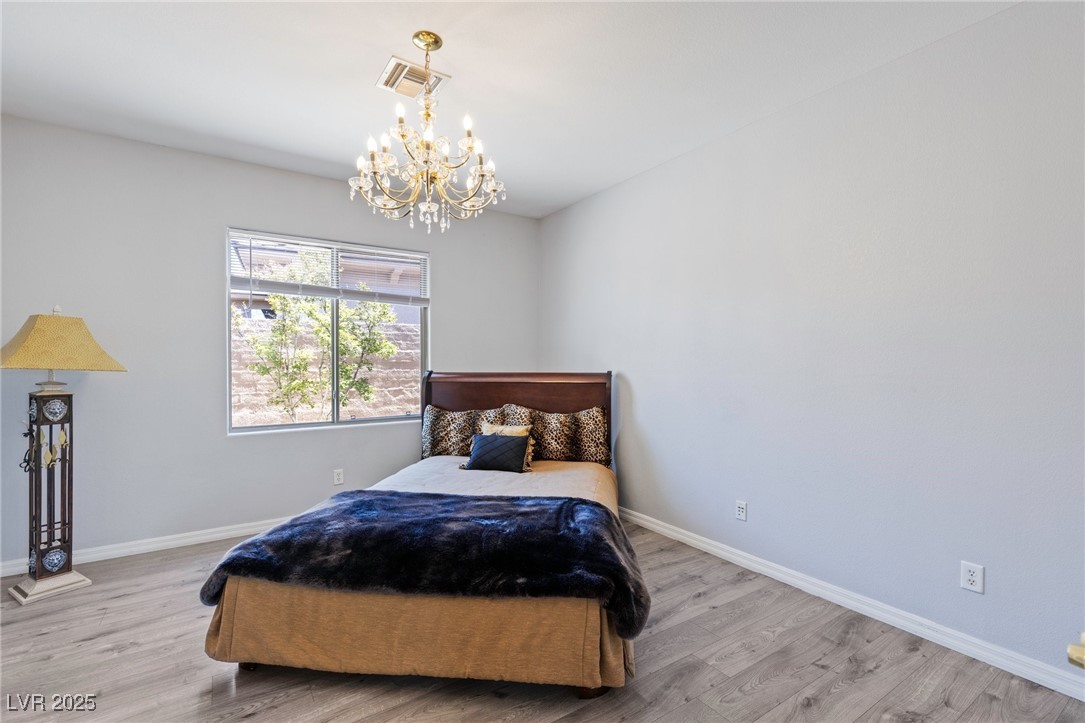 3 Chatmoss Road Henderson, NV 89052 - Photo 19 of 41 Bedroom with a chandelier, wood finished floors, and baseboards