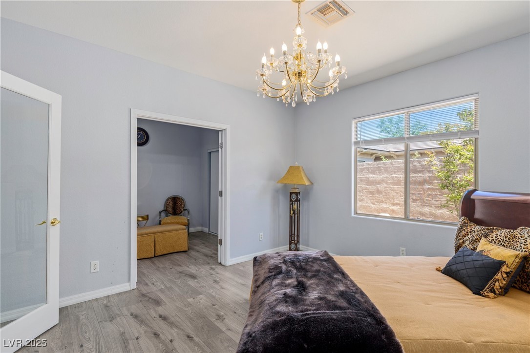 3 Chatmoss Road Henderson, NV 89052 - Photo 20 of 41 Bedroom featuring wood finished floors, a chandelier, and baseboards
