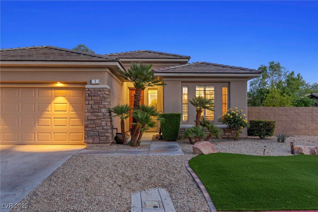3 Chatmoss Road Henderson, NV 89052 - Photo 3 of 41 View of front facade featuring a tile roof, a garage, concrete driveway, stone siding, and stucco siding