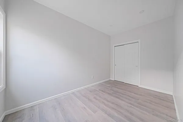 a view of a room with wooden floor and a bathroom