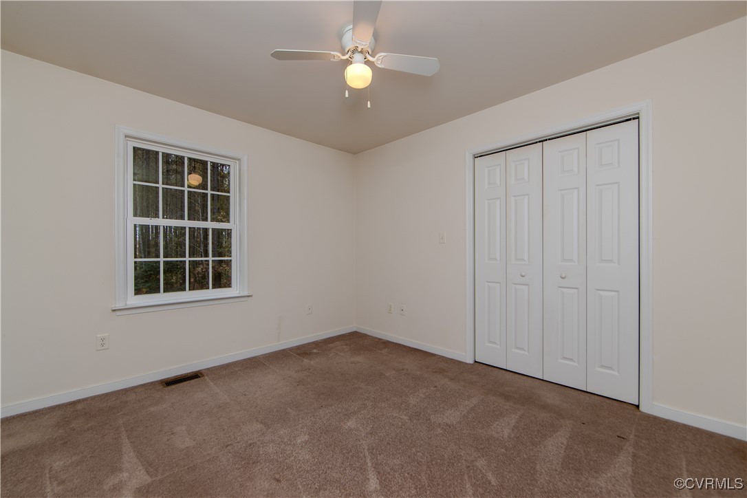 9595 Holdsworth Road Disputanta, VA 23842 - Photo 20 of 28 an empty room with windows and fan