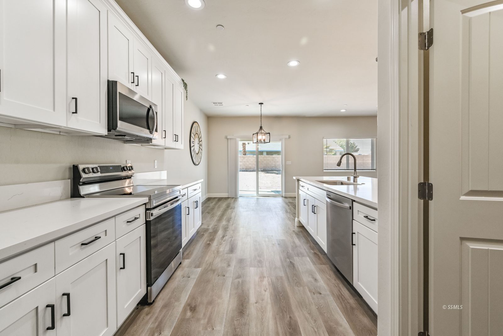 1031 West Church Avenue Ridgecrest, CA 93555 - Photo 8 of 49 a large kitchen with stainless steel appliances granite countertop a lot of counter space and wooden floor