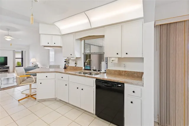 a kitchen with granite countertop white cabinets and white appliances