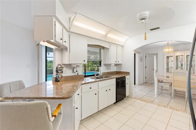 a kitchen with kitchen island granite countertop a sink cabinets and refrigerator