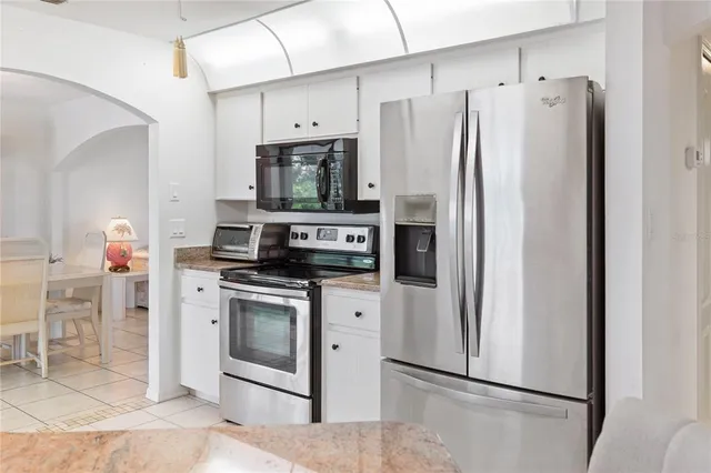 a kitchen with stainless steel appliances a refrigerator a stove a microwave and dining table