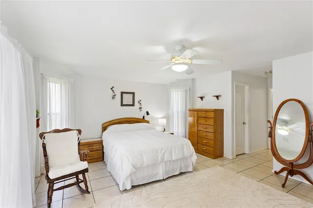 a bedroom with a bed a chair and dresser