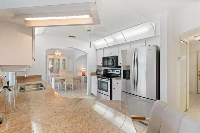 a kitchen with stainless steel appliances granite countertop a refrigerator and a stove top oven