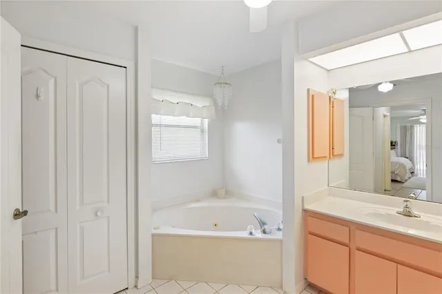 a bathroom with a tub a sink and mirror