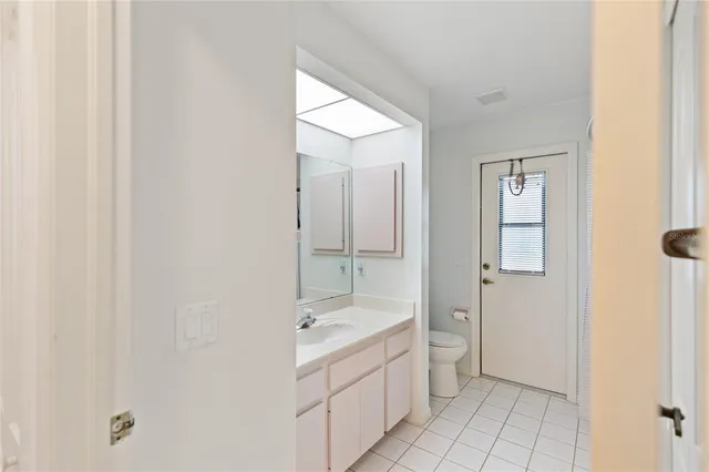 a bathroom with a granite countertop sink a toilet and shower