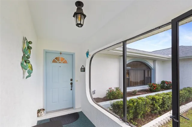 an entryway to room with wooden floor mirror and window