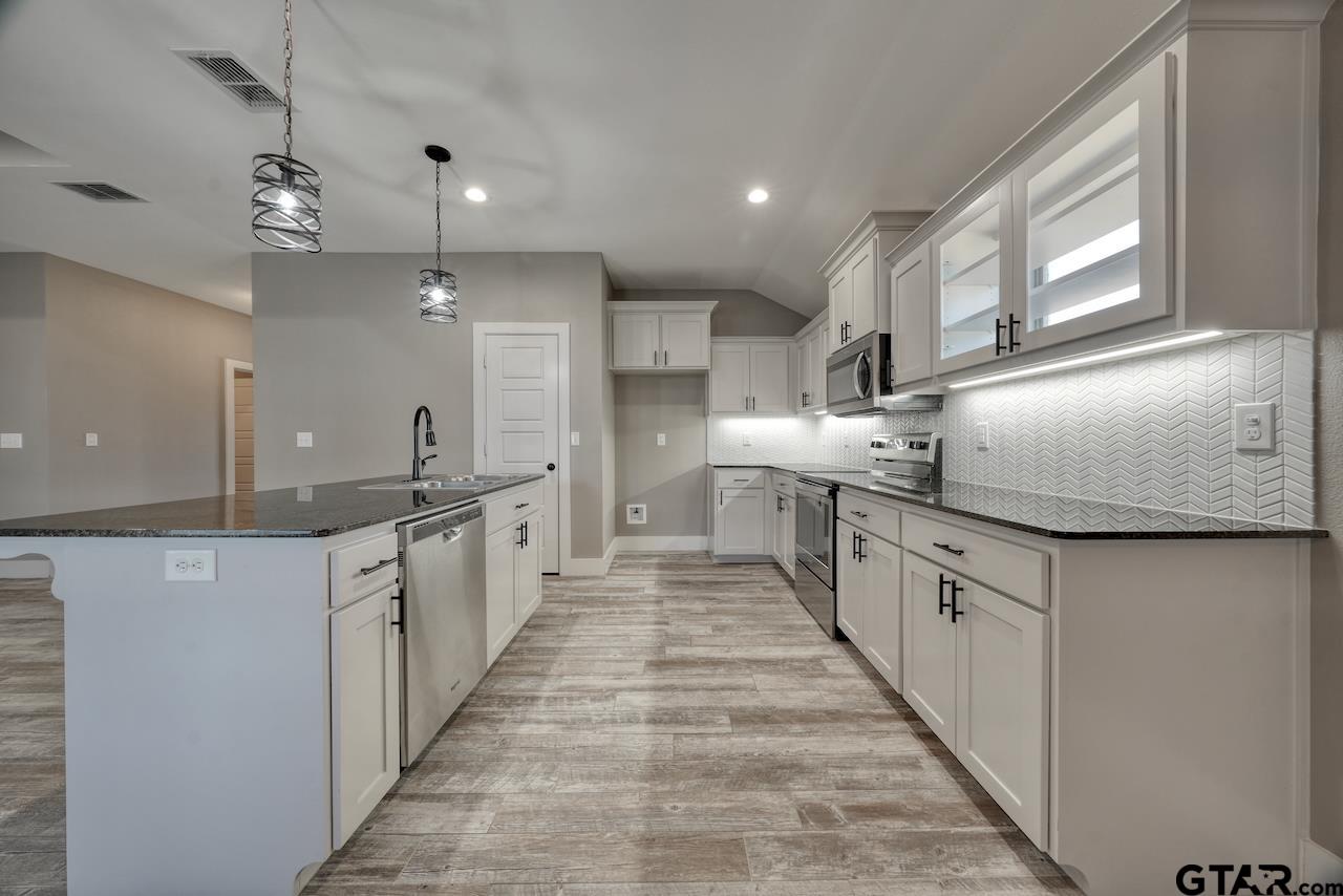15342 Spring Oaks Drive Lindale, TX 75771 - Photo 13 of 45 a large kitchen with kitchen island a sink a counter top space and stainless steel appliances