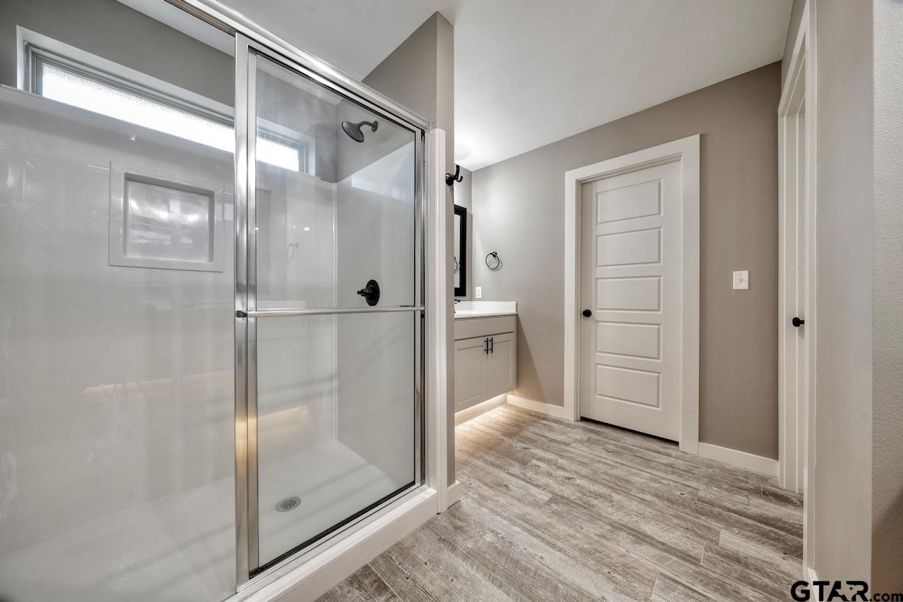 15342 Spring Oaks Drive Lindale, TX 75771 - Photo 25 of 45 a bathroom with a glass shower door and a mirror