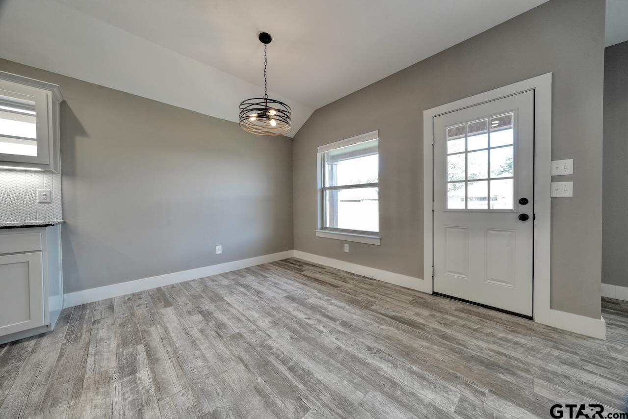15342 Spring Oaks Drive Lindale, TX 75771 - Photo 7 of 45 an empty room with wooden floor a ceiling fan and windows
