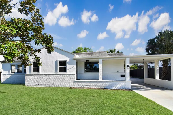 front view of a house with a yard and a tree