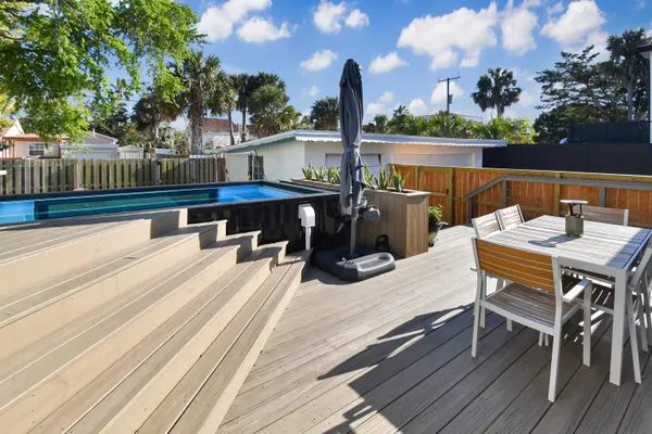 a view of a patio with dining table and chairs with wooden floor