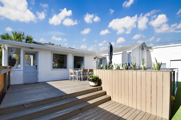 a front view of a house with a garden and trees