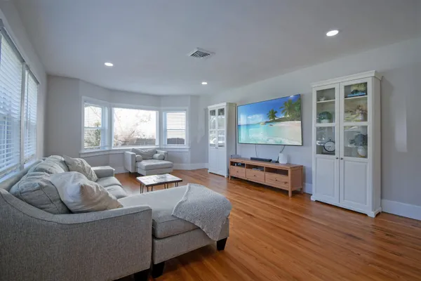 a living room with furniture and a wooden floor