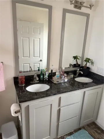 a bathroom with a granite countertop sink and a mirror