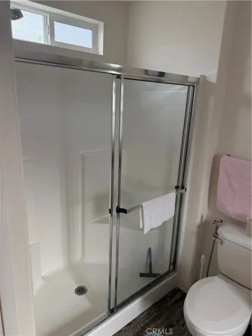 a bathroom with a toilet and a shower