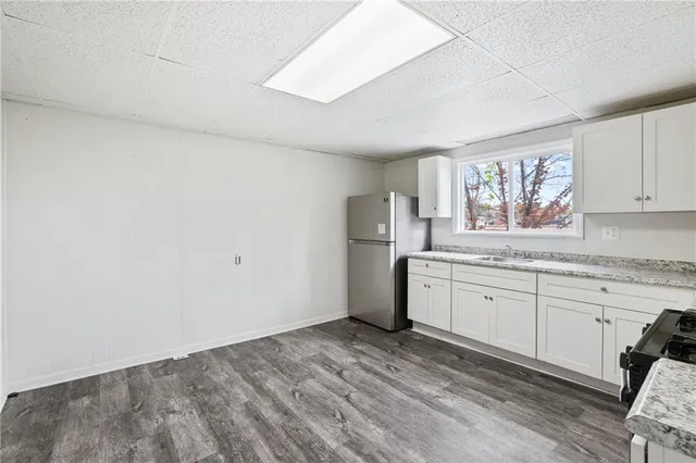 a kitchen with granite countertop a sink cabinets stainless steel appliances and a window