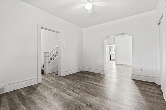 an empty room with wooden floor and white walls