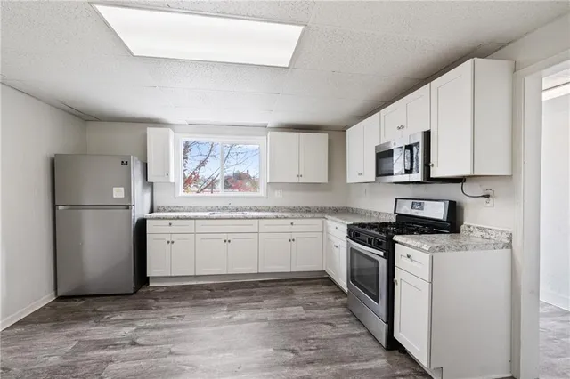 a kitchen with granite countertop a refrigerator stove top oven and sink