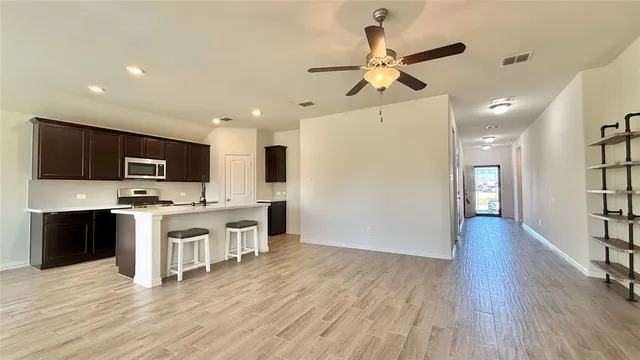 a view of kitchen with microwave a stove and furniture