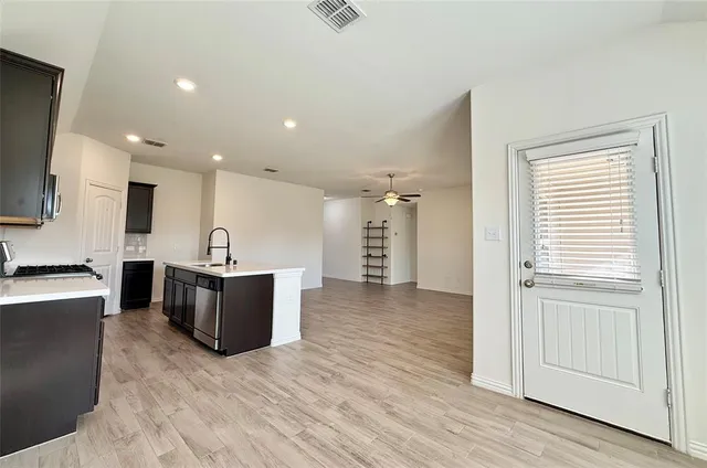 a large kitchen with a lot of counter space and wooden floor