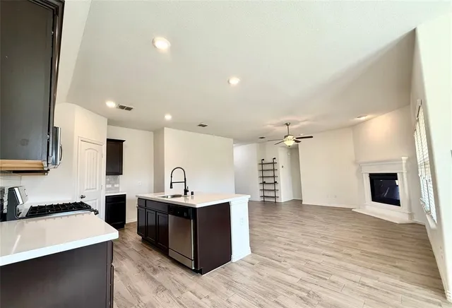 a kitchen with stainless steel appliances a sink a stove top oven a counter space and cabinets