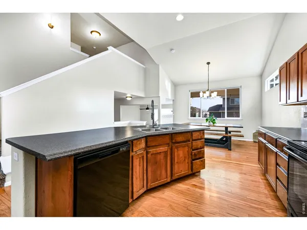 a kitchen with stainless steel appliances granite countertop a stove a sink and a wooden floors