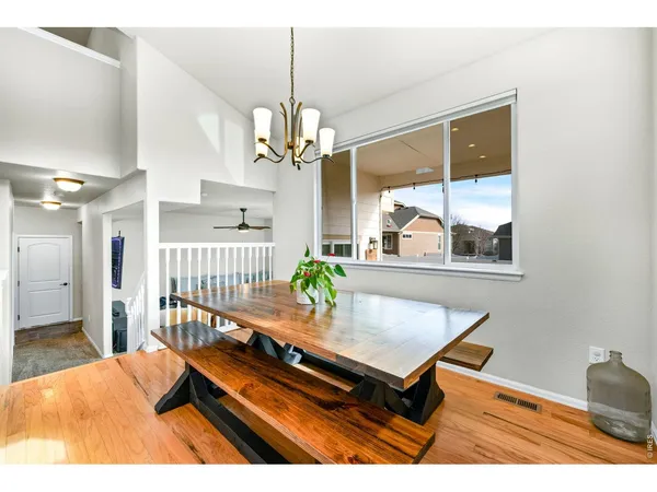 a dining room with furniture a chandelier and wooden floor