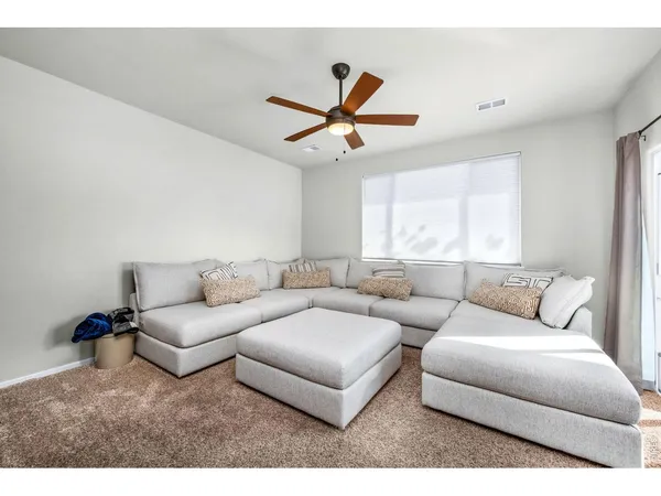 a living room with furniture and a ceiling fan
