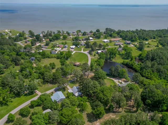 an aerial view of residential house with outdoor space and trees all around