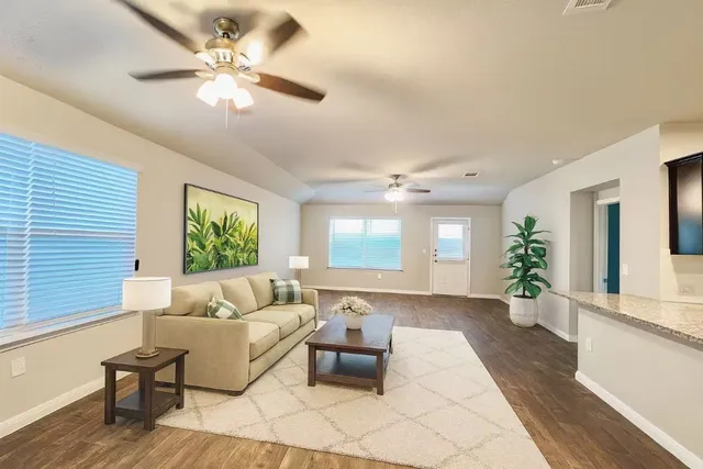 a living room with furniture and wooden floor